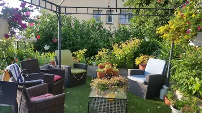 a garden with chairs and tables and plants at La Tuiliere in Saint-Laurent-du-Var