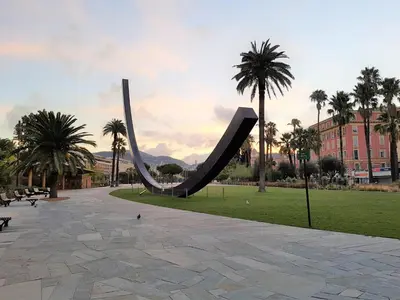 a slide in a park with palm trees and a building at R.D.V. Duplex Nice Center in Nice