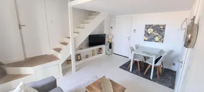 a white living room with a staircase and a table at R.D.V. Duplex Nice Center in Nice