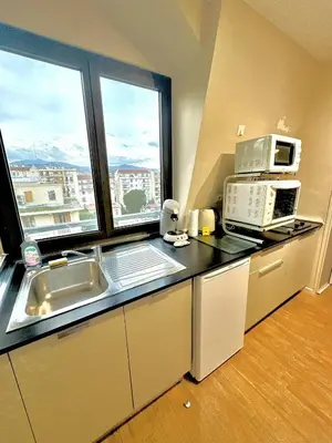 a kitchen with a sink and a microwave and a window at Nice Centre, Magnifique Studio Proche Mer in Nice