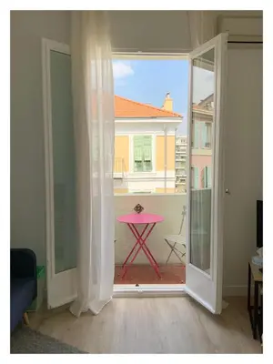 a room with a pink table on a balcony at Maison de Côte - Felice in Nice