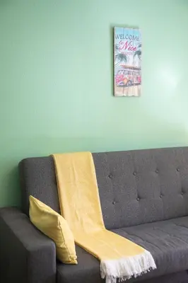 a couch with a yellow blanket on top of it at Cosy apartment Promenade des Anglais in Nice