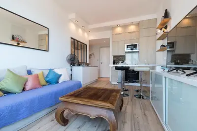 a living room with a blue couch and a table at Sea View - Promenade des Anglais 1 Bdr in Nice