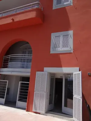 an orange building with white shutters and a door at Les pieds dans la mer Best place in Villefranche-sur-Mer