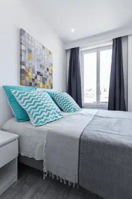 a bedroom with a bed with blue pillows and a window at Olma in Nice