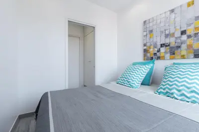 a bedroom with a bed with blue and white pillows at Olma in Nice