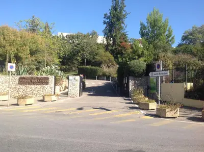 a parking lot with a gate and a street sign at La Nectarine in Nice