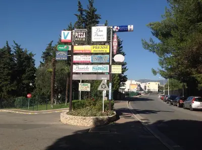 a bunch of signs on a pole on a street at La Nectarine in Nice