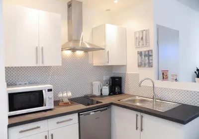 a kitchen with white cabinets and a microwave and a sink at Suite Imperazur Five stars Holiday House in Nice
