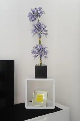 a vase of purple flowers on a white stand at Suite Imperazur Five stars Holiday House in Nice