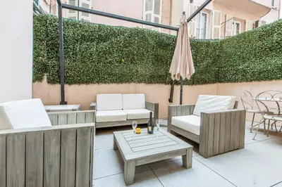 a patio with two chairs and a table and an umbrella at Grimaldi in Nice