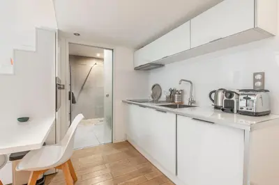 a kitchen with white cabinets and a sink at Grimaldi in Nice