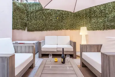 a patio with two beds and a table and chairs at Grimaldi in Nice