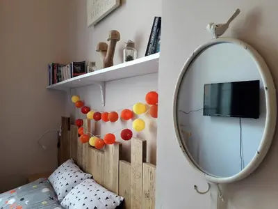 a bedroom with a mirror and a bed and a tv at La Maïoun Guesthouse in Nice