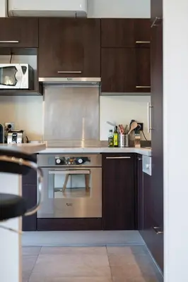 a kitchen with wooden cabinets and a stainless steel oven at Appartement Musiciens in Nice