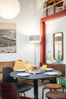 a table with a plate of food on it in a living room at Nice-Duplex-Plage-Climatisation in Nice