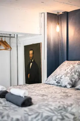 a bedroom with a blue chair and a mirror at Nice-Duplex-Plage-Parking-Cimatisation in Nice