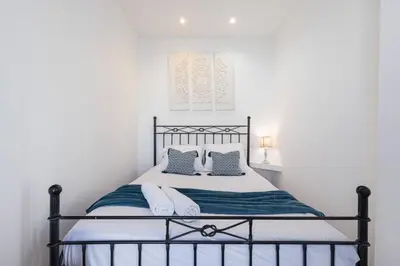 a bedroom with a black and white bed with pillows at MY CASA - BUFFA 21 - 2min from the Sea - Terrace in Nice