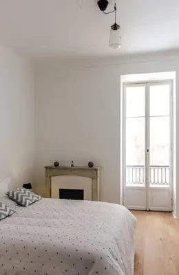 a white bedroom with a bed and a fireplace at MY CASA - VEILLON - 2 bedrooms - City Center in Nice