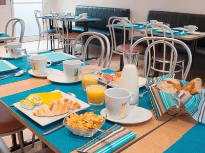 a table with breakfast foods and drinks on it at Hôtel Esprit d'Azur in Nice