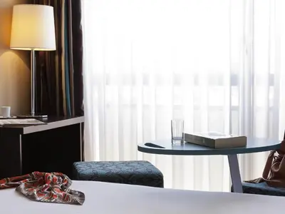 a bedroom with a vase of flowers on a wall at ibis Styles Beaulieu sur Mer in Beaulieu-sur-Mer