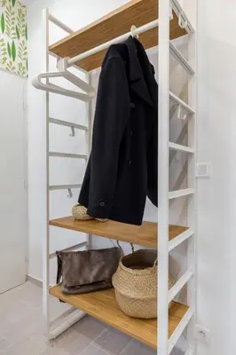 a closet with wooden shelves and a coat on it at Casa Madere- Idéal Couples - Central & cosy -Train station - Tram & Supermarkets-Balcony- Washing-machine-AC in Nice