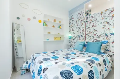 a bedroom with a bed with a blue and white comforter at Casa Madere- Idéal Couples - Central & cosy -Train station - Tram & Supermarkets-Balcony- Washing-machine-AC in Nice
