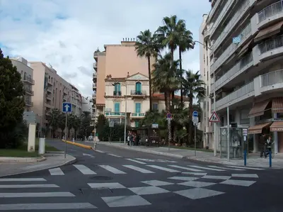 an empty city street with palm trees and buildings at Affitto-Nizza in Nice