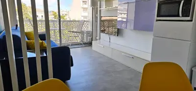 a kitchen with yellow chairs and a balcony with a view at Affitto-Nizza in Nice