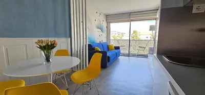 a living room with a table and a blue couch at Affitto-Nizza in Nice