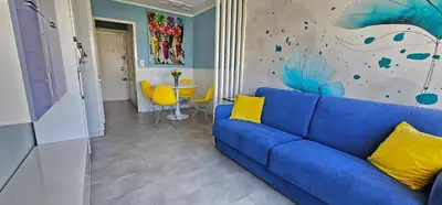a living room with a blue couch and a table at Affitto-Nizza in Nice