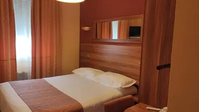 a bedroom with a bed with a wooden headboard at Residence Share Inn in Nice