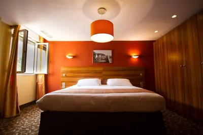 a bedroom with a large bed with an orange wall at Residence Share Inn in Nice