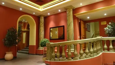 a staircase in a building with red walls and columns at Residence Share Inn in Nice