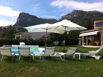 a group of chairs and umbrellas next to a pool at Bed & Breakfast Les LILLAS in Saint-Jeannet
