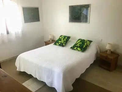 a bedroom with a white bed with two green pillows at Bed & Breakfast Les LILLAS in Saint-Jeannet