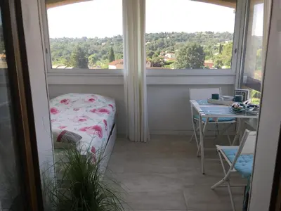 a room with a window and a table and a bed at Bed & Breakfast Les LILLAS in Saint-Jeannet