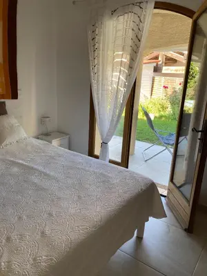a bedroom with a bed and a sliding glass door at Bed & Breakfast Les LILLAS in Saint-Jeannet