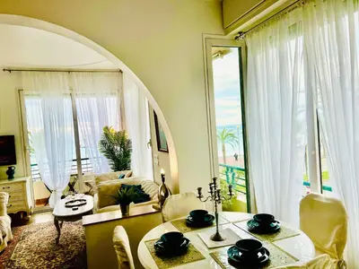 a living room with a table and a large window at Endless Stunning Mediterranean Sea Views Promenade Des Anglais in Nice