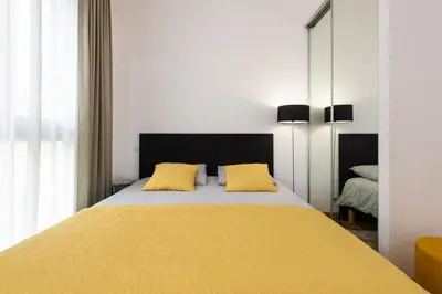 a bedroom with a large yellow bed with yellow pillows at Le Foch in Nice