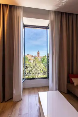 a room with a large window with a view at GRAND HÔTEL Golden Square 3 min to Beach Green Corridor View AC in Nice