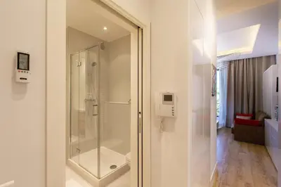 a bathroom with a shower with a glass door at GRAND HÔTEL Golden Square 3 min to Beach Green Corridor View AC in Nice