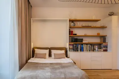 a bedroom with a bed and a book shelf at GRAND HÔTEL Golden Square 3 min to Beach Green Corridor View AC in Nice