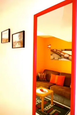 a living room with a couch and a mirror at Studios Nice French Riviera in Nice
