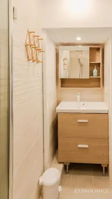 a bathroom with a sink and a toilet and a mirror at CondoNice in Nice