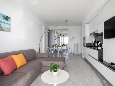 a kitchen with white cabinets and a view of the ocean at Apartment L'Angelina-1 by Interhome in Cros-de-Cagnes