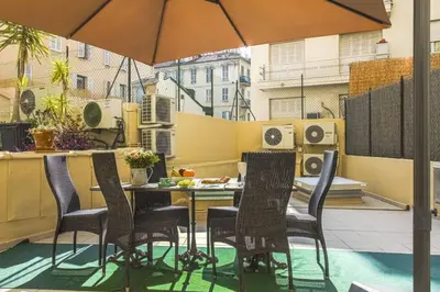 a table and chairs on a balcony with an umbrella at MY CASA - JOFFRE 9 - Near Masséna Square - Terrace in Nice