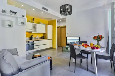 a living room and kitchen with a couch and a table at MY CASA - FRANCE 82 D - 2 rooms - Terrace - 1 min to the Sea in Nice
