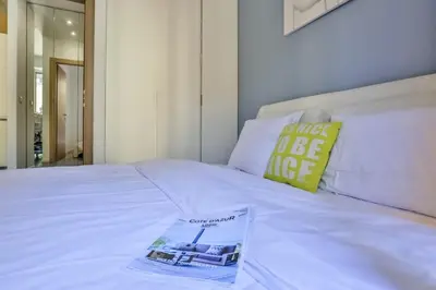 a white bed with a magazine sitting on top of it at MY CASA - FRANCE 82 D - 2 rooms - Terrace - 1 min to the Sea in Nice