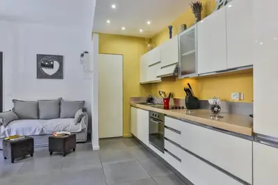 a kitchen and a living room with a couch at MY CASA - FRANCE 82 D - 2 rooms - Terrace - 1 min to the Sea in Nice
